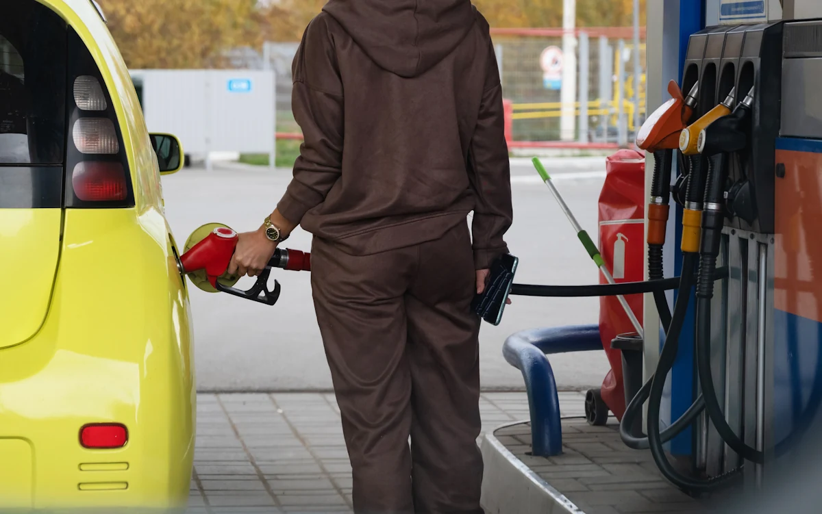 Une femme qui remplit le réservoir de sa voiture