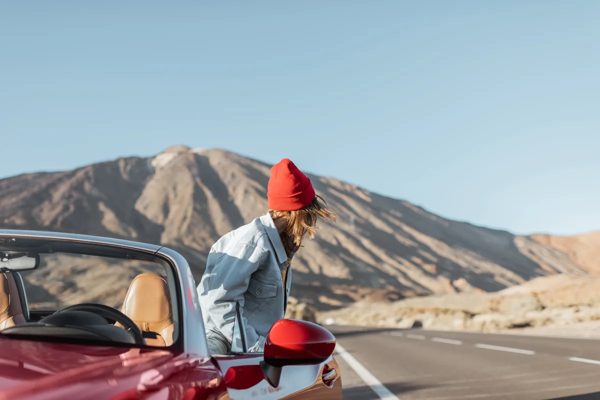 une femme qui monte dans une voiture rouge
