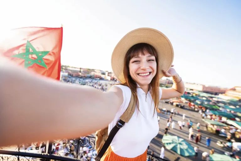 Une femme qui se prend en photo ave e drapeau du Maroc