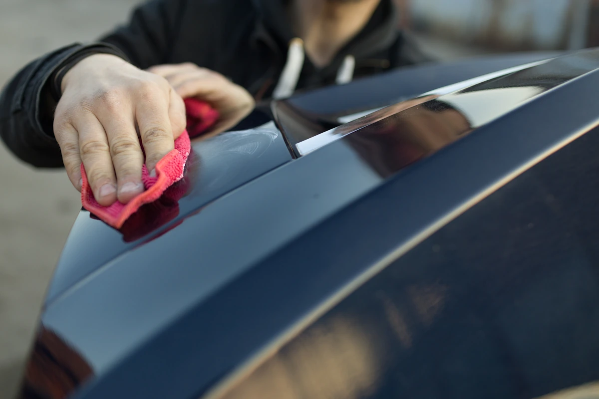 une personne qui applique du polish sur une voiture